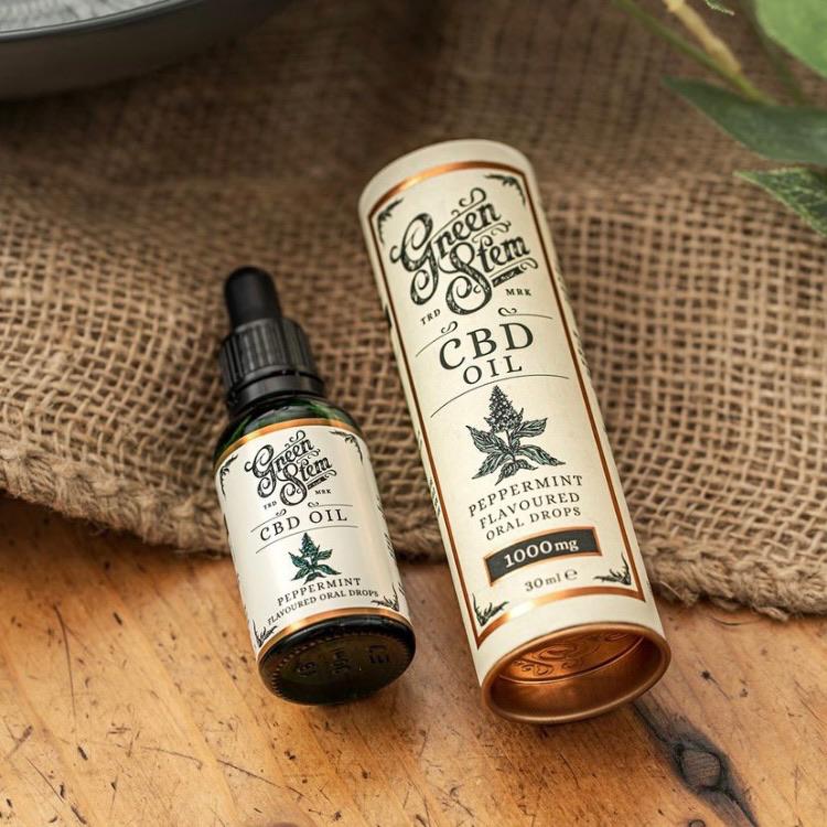 CBD oil in glass bottle against jute on wooden table from eco sustainable shop